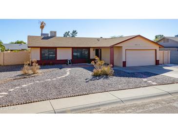 Single-story house with a two-car garage and well-maintained landscaping at 2613 E Michigan Ave, Phoenix, AZ 85032