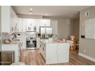 Modern kitchen with white cabinets, stainless steel appliances, and a large island at 2830 N 19Th Ave, Phoenix, AZ 85009