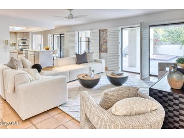 Bright living room with comfy sofas, a large area rug, and access to a patio at 3117 E Sierra Madre Way, Phoenix, AZ 85016