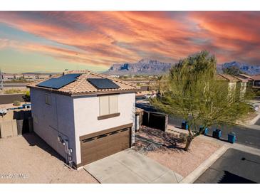 Two-story house with solar panels and a brown garage door, mountain views in the background at 3234 S Bowman Rd, Apache Junction, AZ 85119