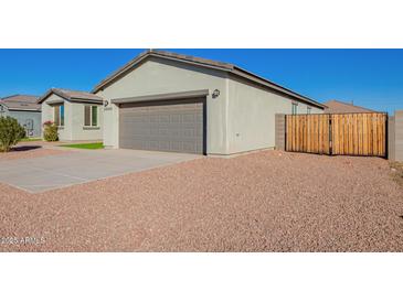 House exterior with gray walls, two-car garage, and a landscaped front yard at 34909 N Palm Dr, San Tan Valley, AZ 85140