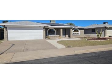 Charming brick home featuring a two-car garage, solar panels, arched windows and desert landscaping at 4054 E Clovis Cir, Mesa, AZ 85206