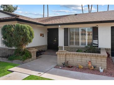 House exterior featuring a walkway, landscaping, and a dark brown front door at 4421 W Laurie Ln, Glendale, AZ 85302