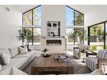 Bright living room features large windows, modern fireplace, and stylish decor at 8255 E Morgan Trl, Scottsdale, AZ 85258