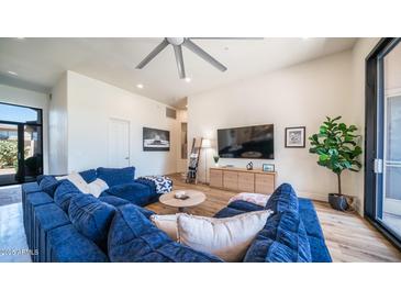 Open living room showcasing a comfortable sectional sofa and large TV at 8277 E Tailspin Ln, Scottsdale, AZ 85255