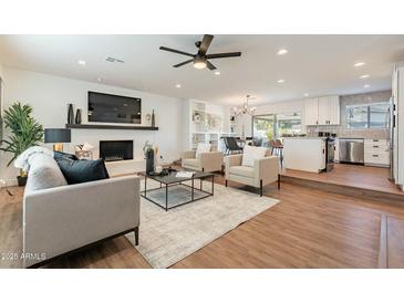 Open living area with fireplace, hardwood floors, and modern furniture at 8732 E Valley Vista Dr, Scottsdale, AZ 85250