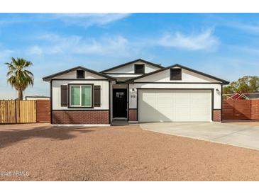 Charming craftsman style home with a white exterior, brick base, and attached two-car garage at 902 S 96Th St, Mesa, AZ 85208