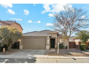 Beige house with a two-car garage and landscaping at 1381 W Birch Rd, Queen Creek, AZ 85140