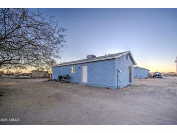 Blue house exterior with a yard and a tree at 1807 S 364Th Ave, Tonopah, AZ 85354