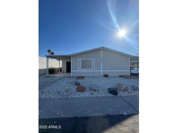 Single-wide manufactured home with carport and small front yard at 245 S 56 St # 174, Mesa, AZ 85206