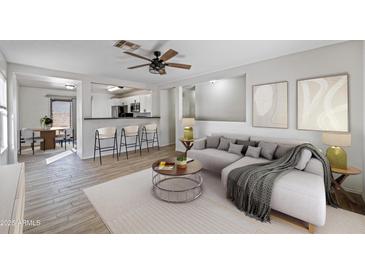 Bright living room featuring neutral tones, open layout, ceiling fan, and modern decor accents at 11782 W Columbine Dr, El Mirage, AZ 85335