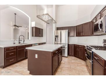 Spacious kitchen with island, stainless steel appliances, and dark wood cabinets at 13345 W Cypress St, Goodyear, AZ 85395