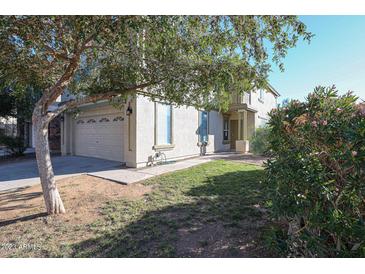 Two-story house with attached garage and landscaping at 13441 W Rose Ln, Litchfield Park, AZ 85340