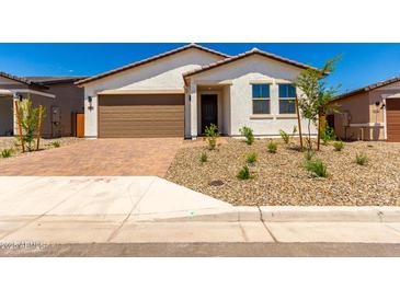 Charming single-story home with a desert landscape and a brown two car garage at 18556 E Dario Rd, Gold Canyon, AZ 85118