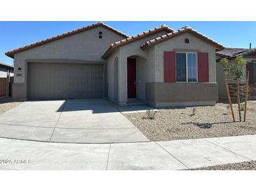 Single-story home with gray exterior, red shutters, and a two-car garage at 20863 N 223Rd Ave, Surprise, AZ 85387