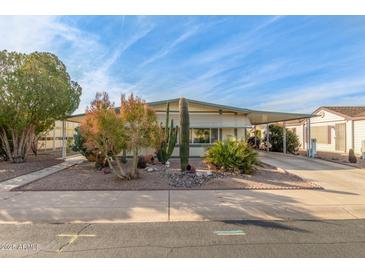 Desert landscaping surrounds this single-level manufactured home with carport at 2724 N Wright Way, Mesa, AZ 85215