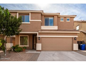 Two-story house with tan exterior, two-car garage, and landscaping at 4723 W Gelding Dr, Glendale, AZ 85306