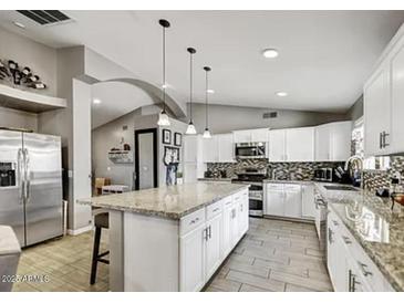 Spacious kitchen with granite countertops, stainless steel appliances, and an island at 8149 W Daley Ln, Peoria, AZ 85383