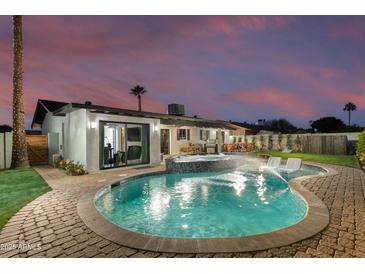 Stunning pool and spa with patio seating at twilight at 8235 E Glenrosa Ave, Scottsdale, AZ 85251