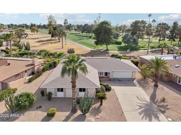 Single-story home with golf course views, spacious driveway and desert landscaping at 9729 W Pinecrest Dr, Sun City, AZ 85351