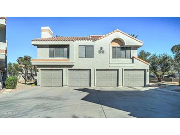Front view of condo with three-car garage and desert landscaping at 10115 E Mountain View Rd # 2022, Scottsdale, AZ 85258