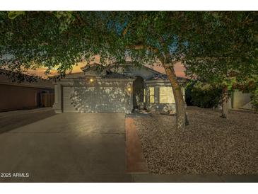 Charming single-Gathering home with a well-maintained front yard and two-car garage, framed by mature shade trees at 13022 W Surrey Ave, El Mirage, AZ 85335