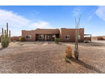 Single-story stucco home with desert landscaping and a spacious front yard at 21335 W Cavalry Dr, Wittmann, AZ 85361