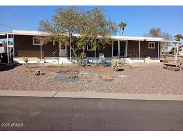 Mobile home with covered porch and desert landscaping at 156 N Hawes Rd # 75, Mesa, AZ 85207