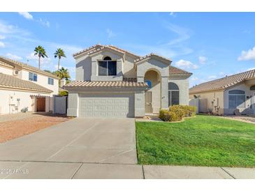 Two-story house with a two-car garage and grassy front yard at 6131 W Irma Ln, Glendale, AZ 85308