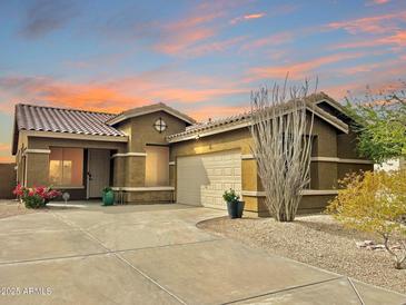 Charming single-story home features desert landscaping, a neutral color scheme, and a two car garage at 17545 W Canyon Ln, Goodyear, AZ 85338