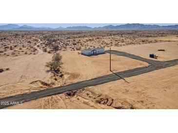 Aerial view of a single-story home on a large lot with mountain views at 53259 W Barn Owl Rd, Maricopa, AZ 85139