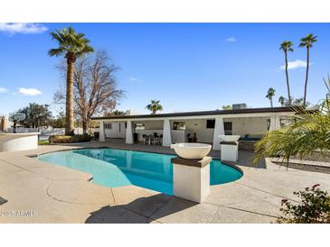 Inviting pool with spacious patio and palm trees at 6542 E Ludlow Dr, Scottsdale, AZ 85254