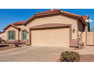 Tan house with tile roof, two car garage, and landscaping at 1410 E Palm Beach Dr, Chandler, AZ 85249