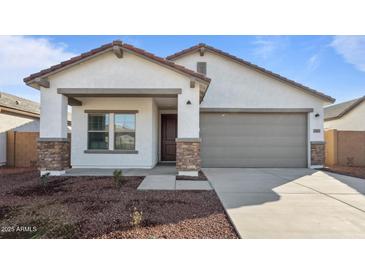 New construction home with a two-car garage and desert landscaping at 3873 S 233Rd Ln, Buckeye, AZ 85326