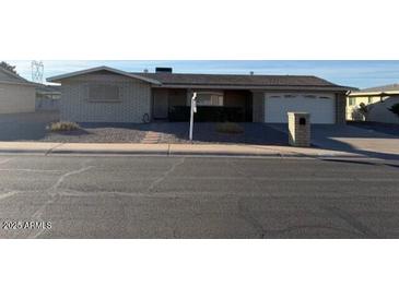 Ranch-style home with a two-car garage and mature landscaping at 6449 E Dallas St, Mesa, AZ 85205