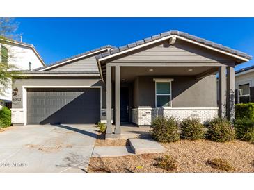 Modern single story home with gray siding, white accents and a covered porch at 10032 E Toledo Ave, Mesa, AZ 85212