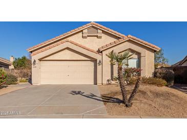 Tan one-story house with two-car garage and desert landscaping at 14529 N 87Th Dr, Peoria, AZ 85381