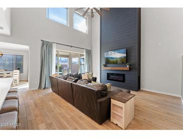 Spacious living room featuring a modern fireplace and high ceilings at 23059 E Pummelos Rd, Queen Creek, AZ 85142