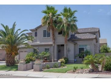 Two-story house with landscaped yard and palm trees at 3469 E Cabazon Ct, Gilbert, AZ 85297