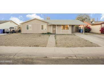 Tan single story house with front yard and driveway at 4216 N 72Nd Ln, Phoenix, AZ 85033