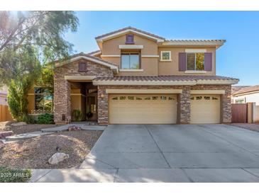 Two-story house with stone accents and a three-car garage at 4221 E Carriage Way, Gilbert, AZ 85297