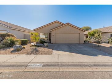 Single-story house with tan exterior, two-car garage, and desert landscaping at 4233 E Creosote Dr, Cave Creek, AZ 85331