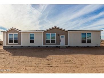 Tan and beige exterior of a manufactured home with a front door and several windows at 7710 S 350Th Ave, Tonopah, AZ 85354