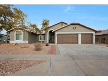 Single-story home with a three-car garage and desert landscaping at 7818 W Encinas Ln, Phoenix, AZ 85043