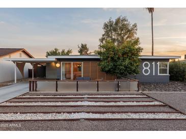 Charming home featuring desert landscaping and a cozy front patio with wood slat privacy screen at 811 W Whitton Ave, Phoenix, AZ 85013