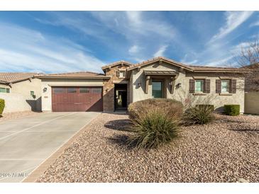 Charming home with a two-car garage, stone accents and low-maintenance desert landscaping at 9144 W Sands Dr, Peoria, AZ 85383