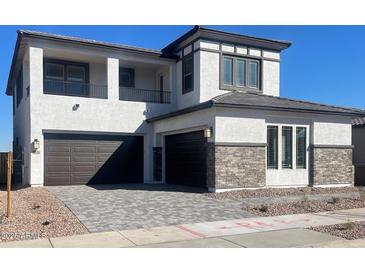 Two-story home with gray brick accents and a paved driveway at 1006 W Superstition Ct, Queen Creek, AZ 85140