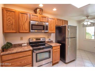 Bright kitchen featuring stainless steel appliances and ample wood cabinetry at 10114 W Campana Dr, Sun City, AZ 85351