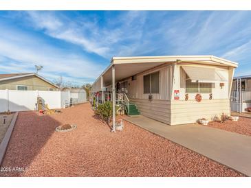 Single-wide manufactured home with carport and landscaped yard at 11411 N 91St Ave # 131, Peoria, AZ 85345