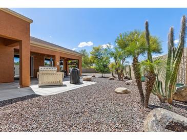 Backyard patio with grill, gravel landscaping, and desert plants at 15338 W Montecito Ave, Goodyear, AZ 85395